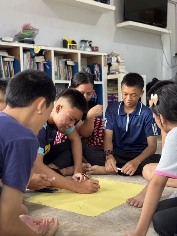 Volunteers helping rural students with a Discovery Camp activity