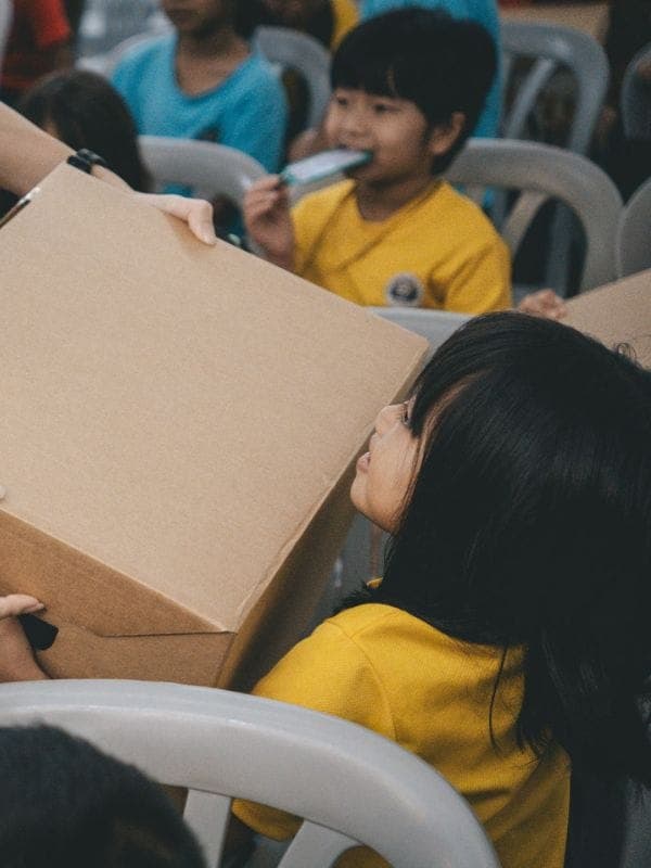 Children receiving gift boxes through the Love Is A Verb project